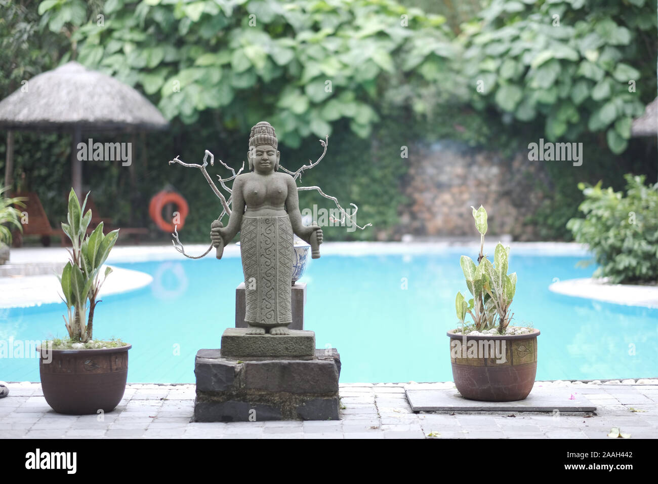 Una estatuilla de la diosa de la fertilidad en el pedestal cerca de la piscina. Vietnam Foto de stock
