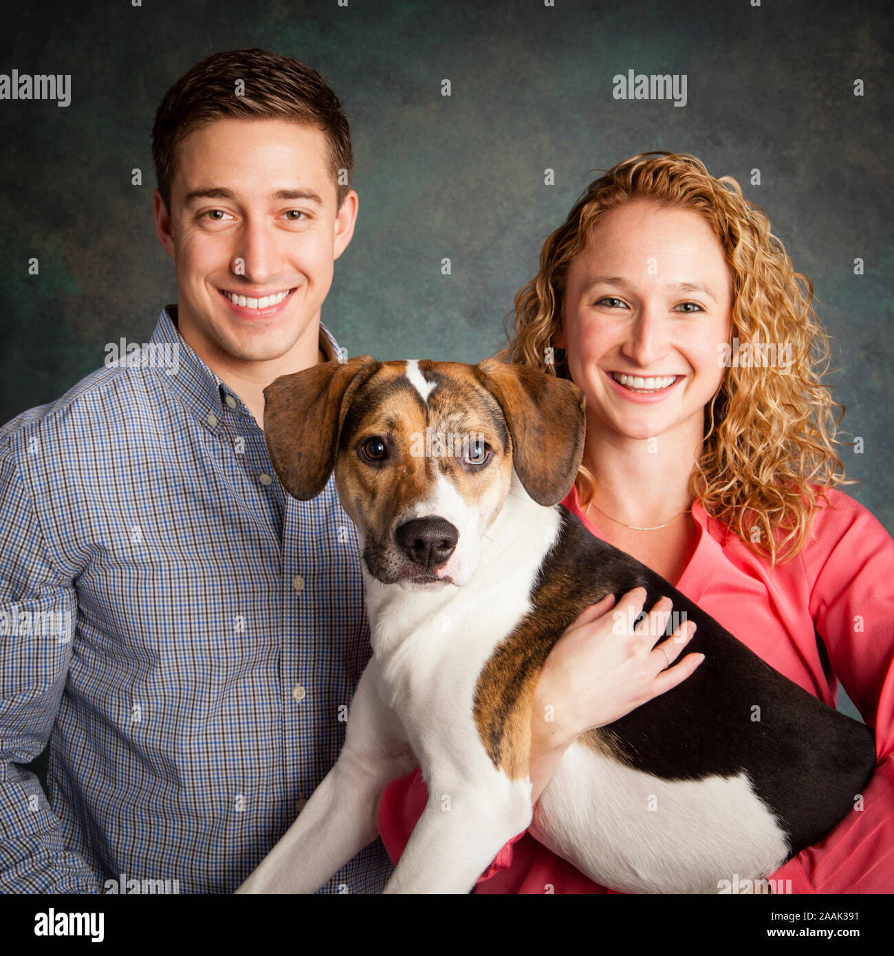 Retrato de estudio de pareja con perro de raza mixta Foto de stock