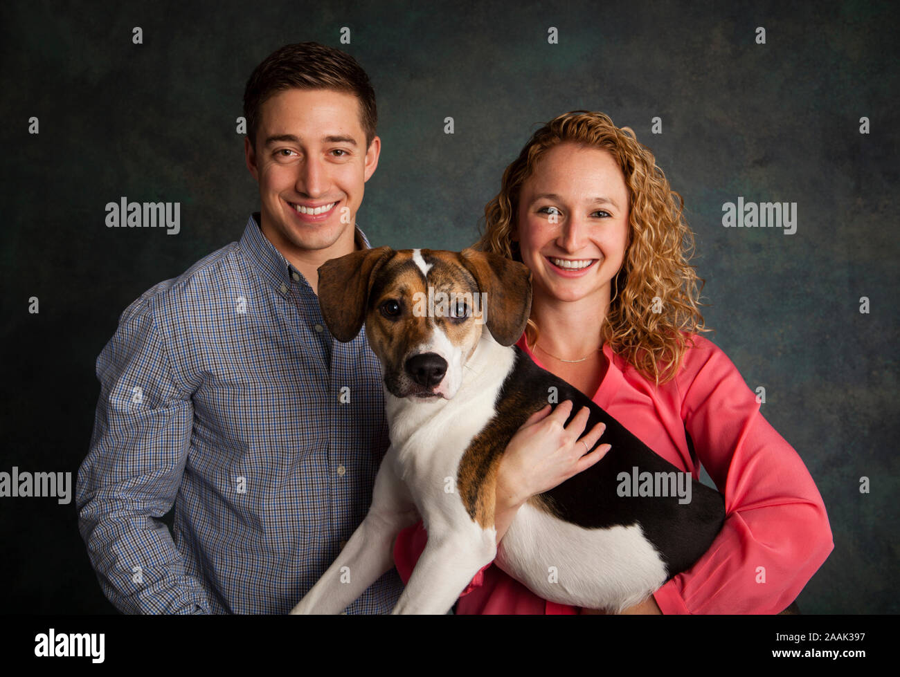 Retrato de estudio de pareja con perro de raza mixta Foto de stock