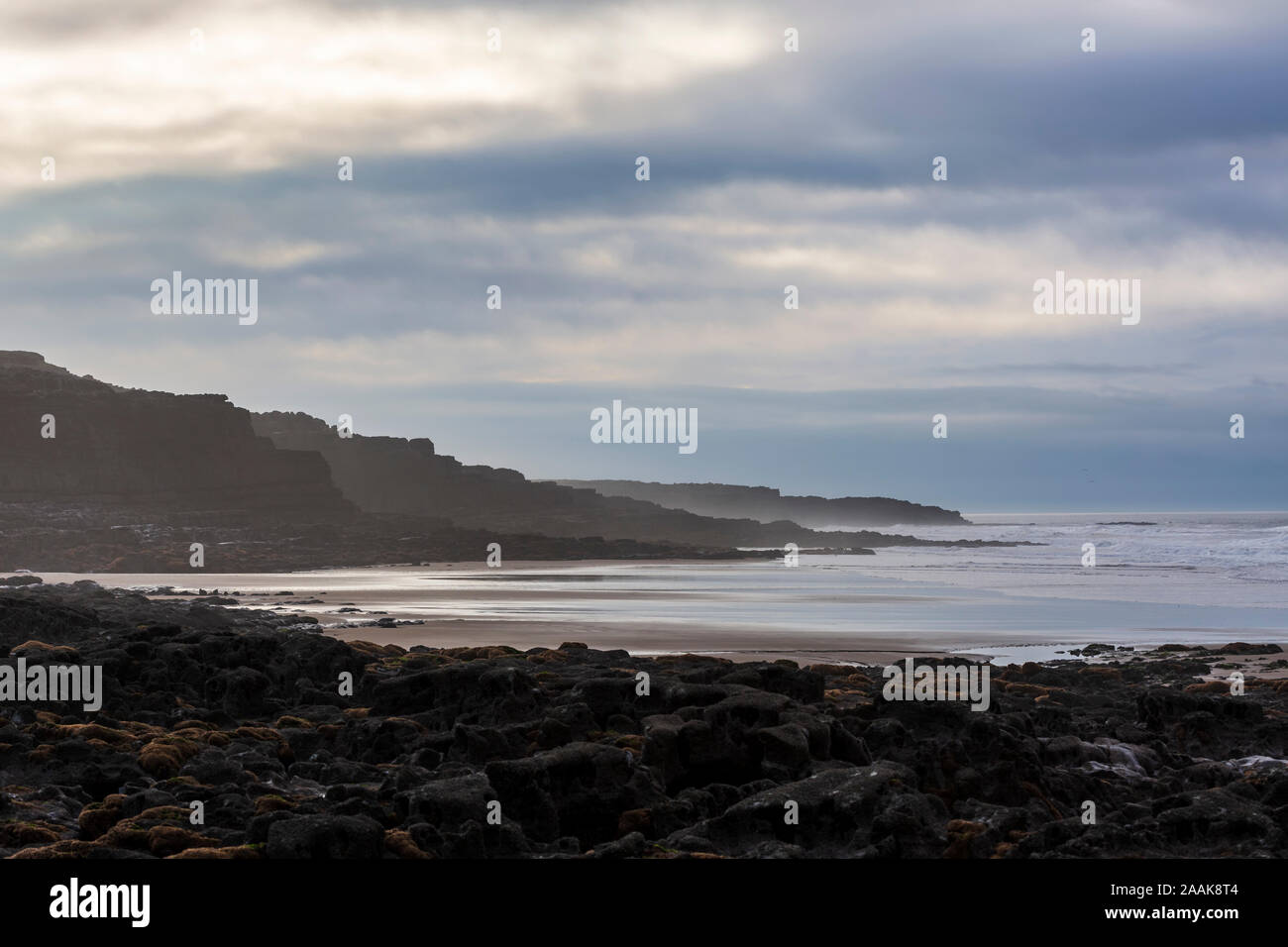 Ver atmosférica de las rocas, la playa y el mar en reposo Bay en Porthcawl, Gales, Reino Unido. Foto de stock