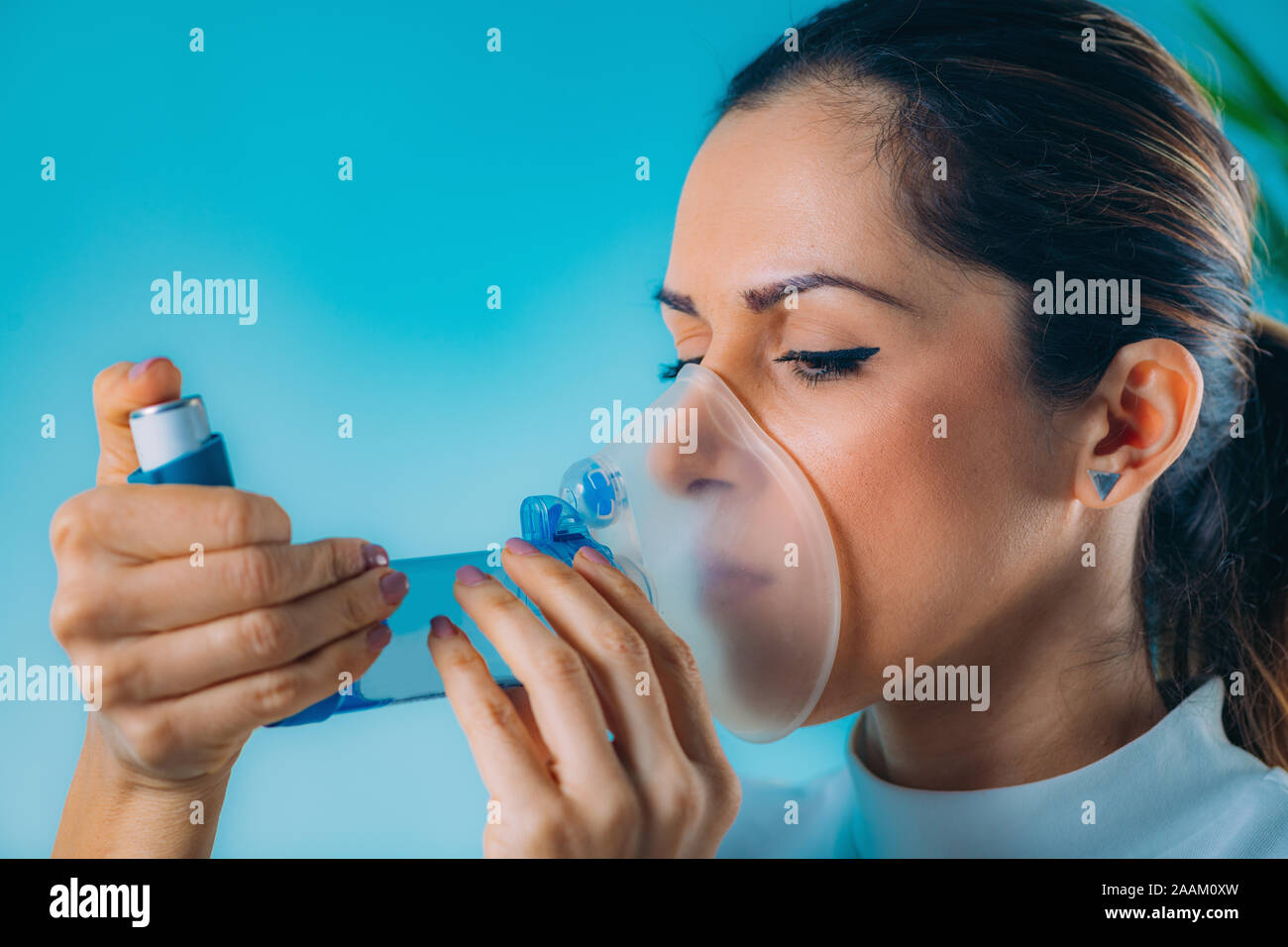 Mujer con inhalador para el asma con tubo de extensión Fotografía de stock  - Alamy