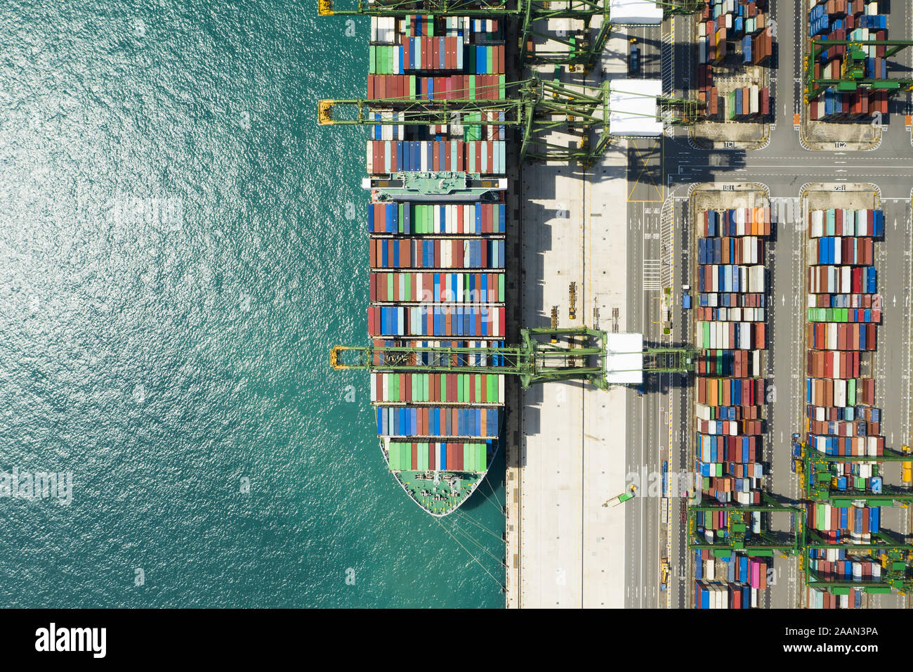 Vista desde arriba, la impresionante vista aérea del puerto de Singapur con cientos de contenedores de color listos para cargar en los buques de carga. Foto de stock