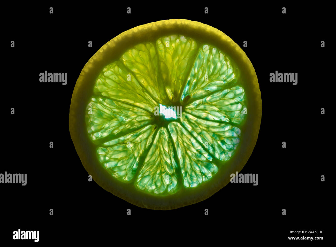Rodaja de naranja con retroiluminación aislado sobre fondo negro Foto de stock