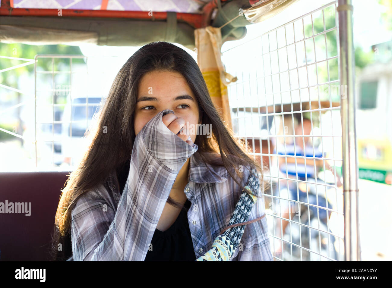 Birracial muchacha adolescente o joven turista taparse la nariz y la boca  de la polución mientras que en taxi tuk tuk en Phnom Pehn, Camboya  Fotografía de stock - Alamy