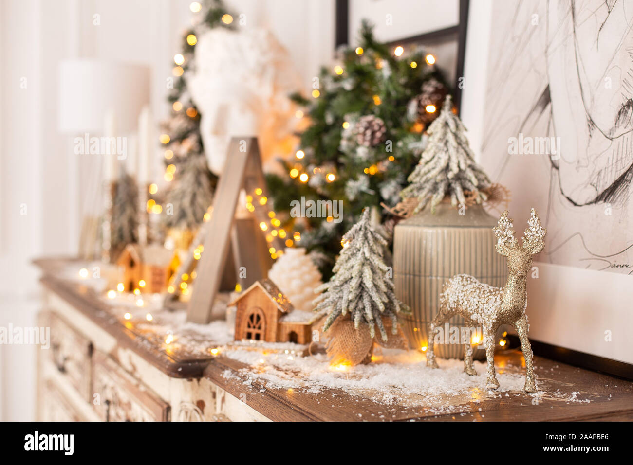 Acercamiento de ciervo de madera de pie sobre fondo de decoración navideña. El enfoque selectivo. Foto de stock