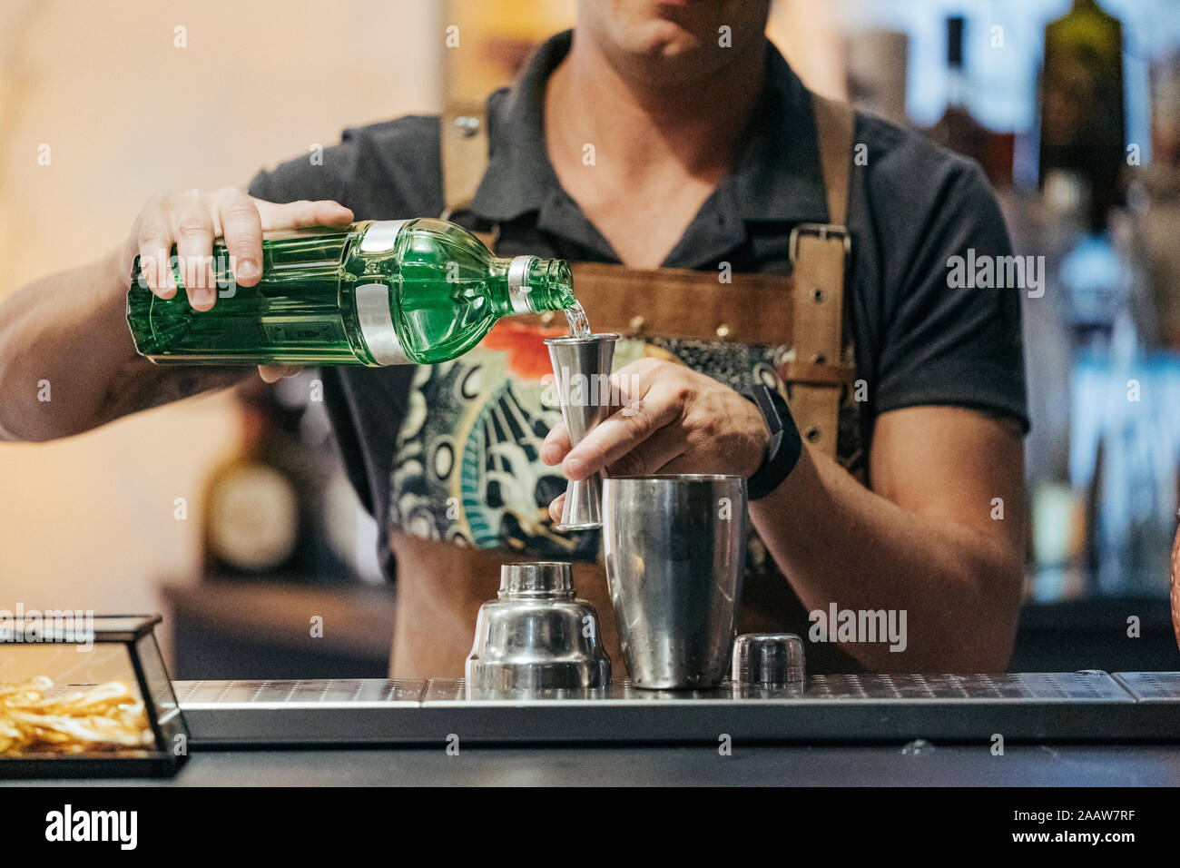 Mezcla de barman en un bar de cócteles, utilizando jigger Foto de stock