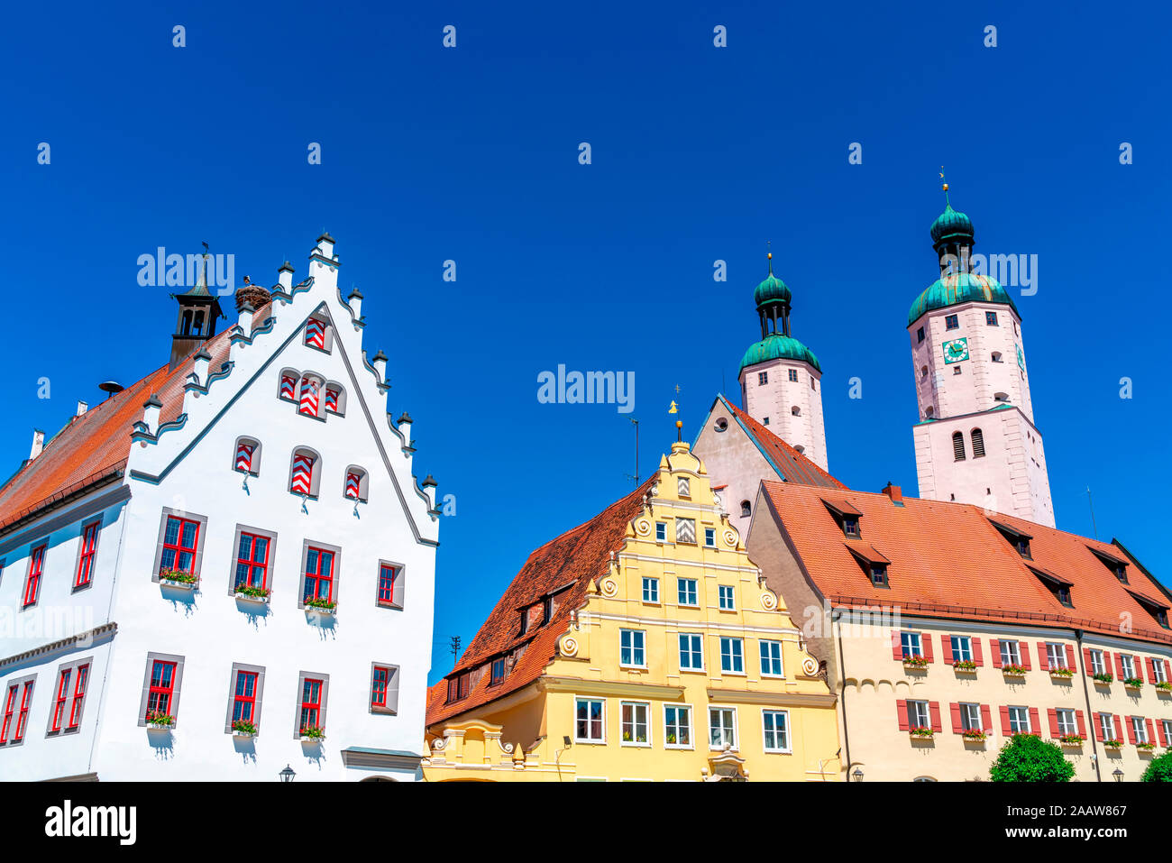Ángulo de visión baja de arquitectura histórica y la iglesia contra el cielo azul claro en Wemding, Baviera, Alemania Foto de stock