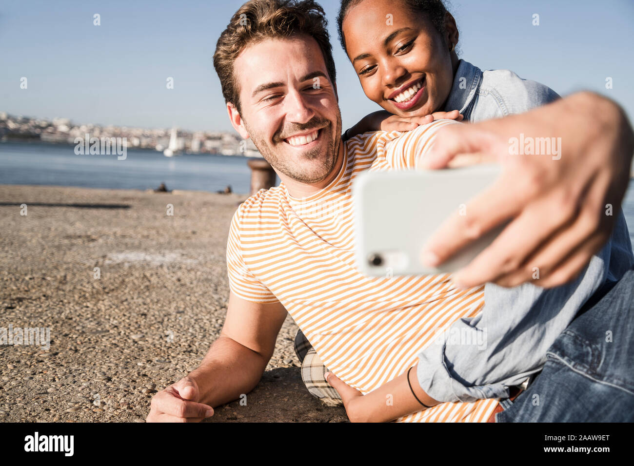 Feliz pareja joven teniendo un selfie en el muelle en el waterfront, Lisboa, Portugal Foto de stock