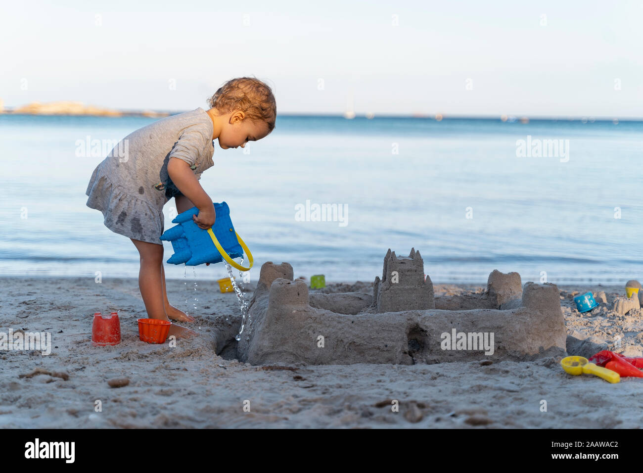 Linda niña niño construir un castillo de arena en la playa Foto de stock