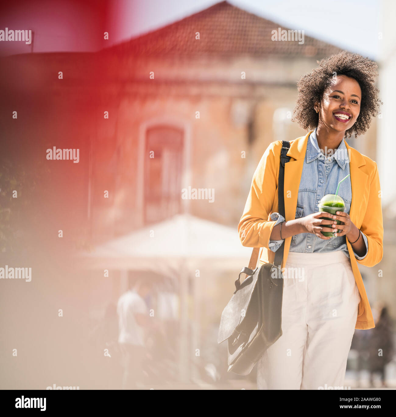 Mujer sonriente en la ciudad sobre la marcha Foto de stock