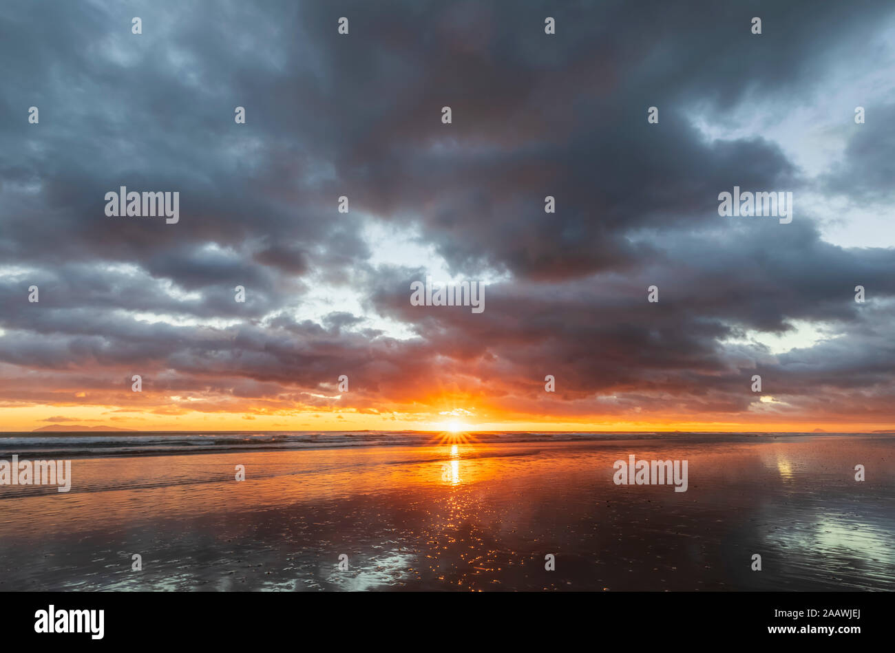 Nueva Zelanda, Isla Norte, Waikato, Waihi Beach, con vistas panorámicas a la playa de Mar al atardecer Foto de stock