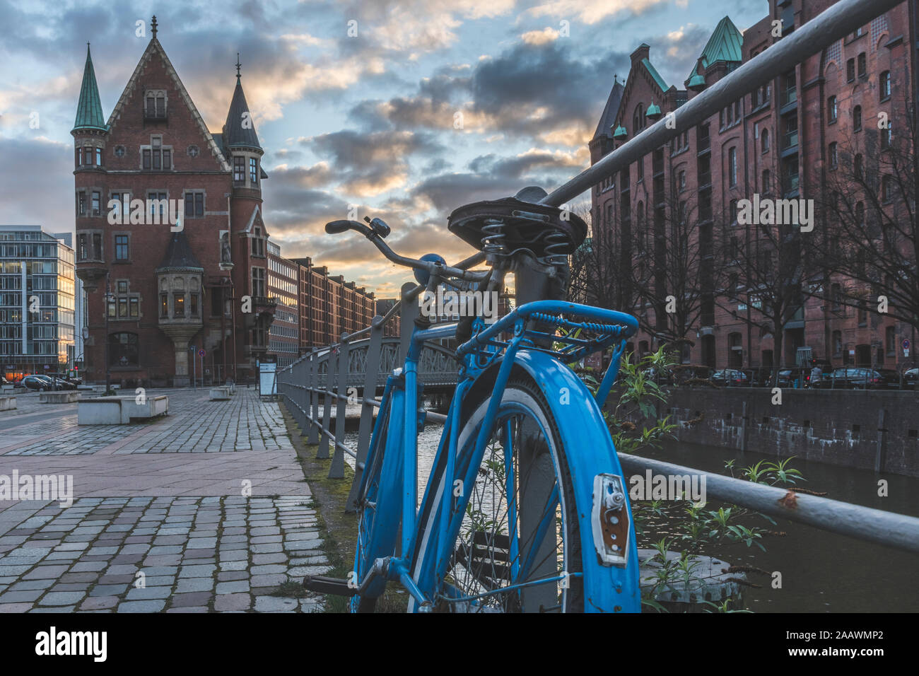 Bicicleta estacionada en la acera frente al atardecer Speicherstadt, Hamburgo, Alemania. Foto de stock
