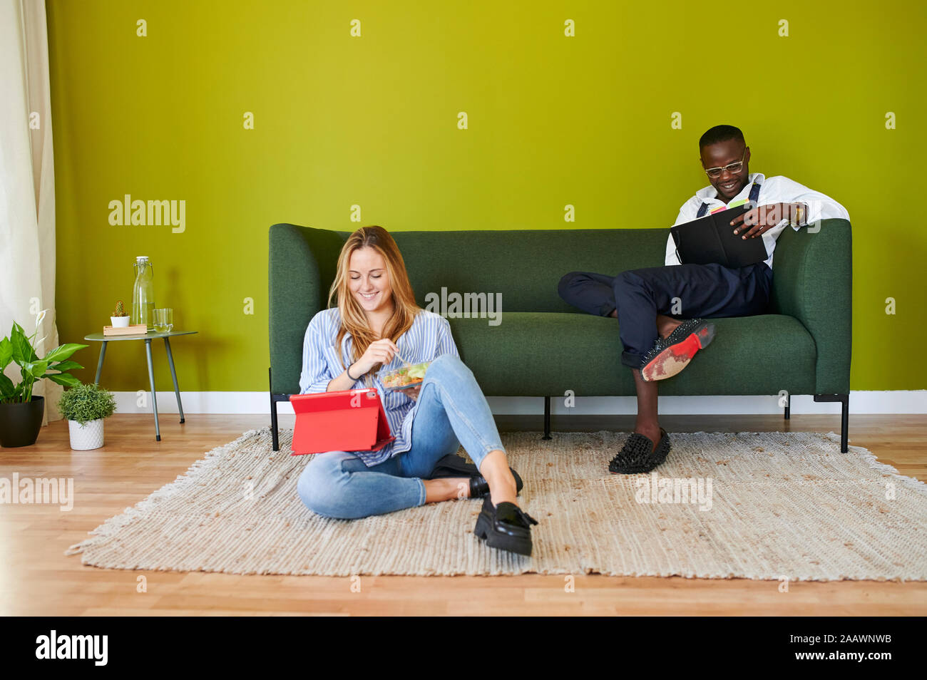 Dos jóvenes empresarios sonriente sentado en el salón en la oficina moderna Foto de stock
