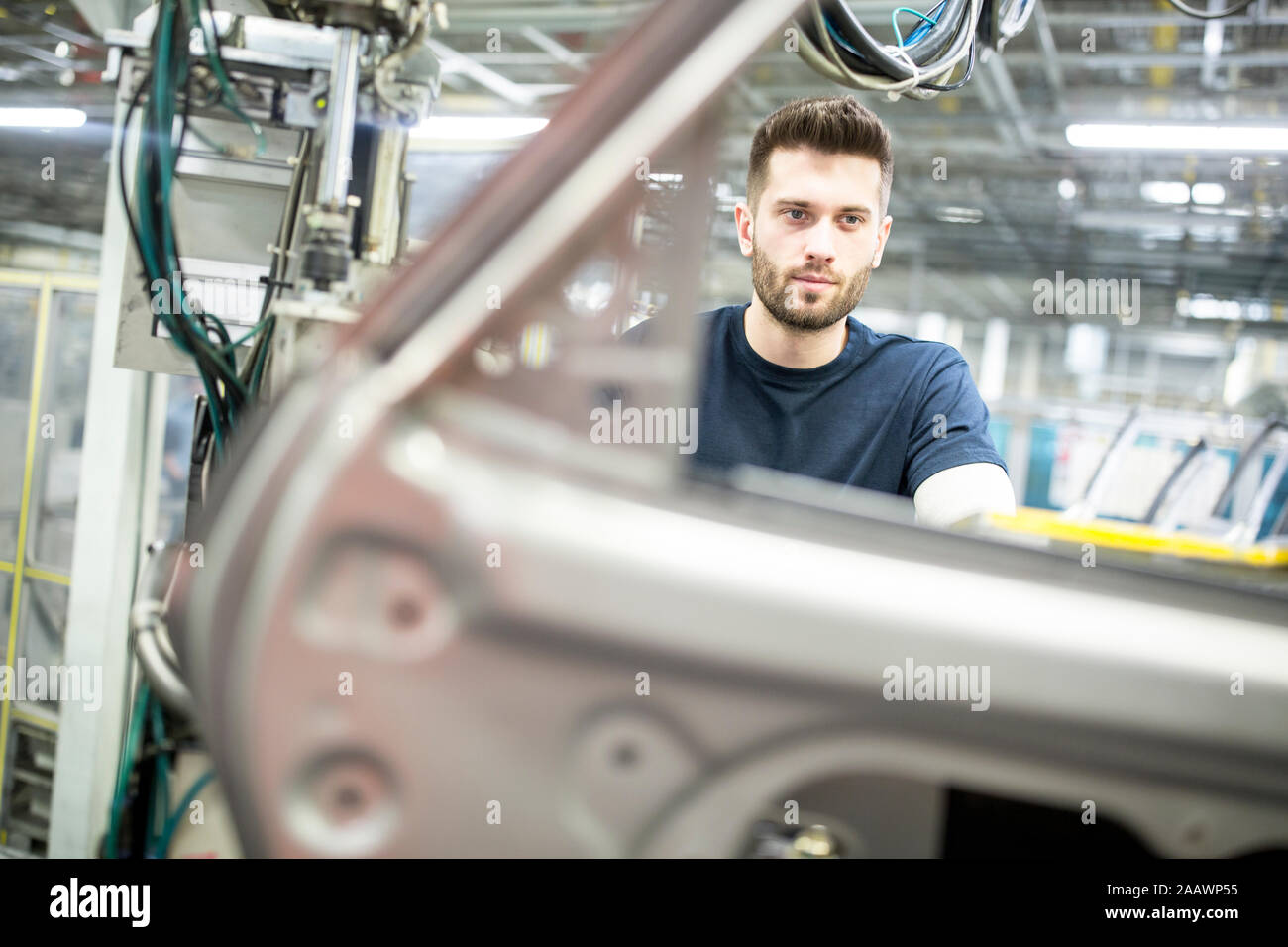 Hombre trabajando en la moderna fábrica de coches Foto de stock