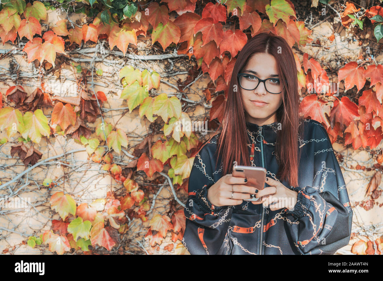 Retrato de una adolescente con el smartphone en otoño Foto de stock