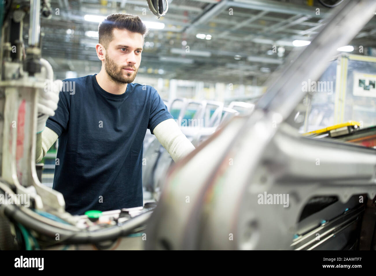 Hombre trabajando en la moderna fábrica de coches Foto de stock