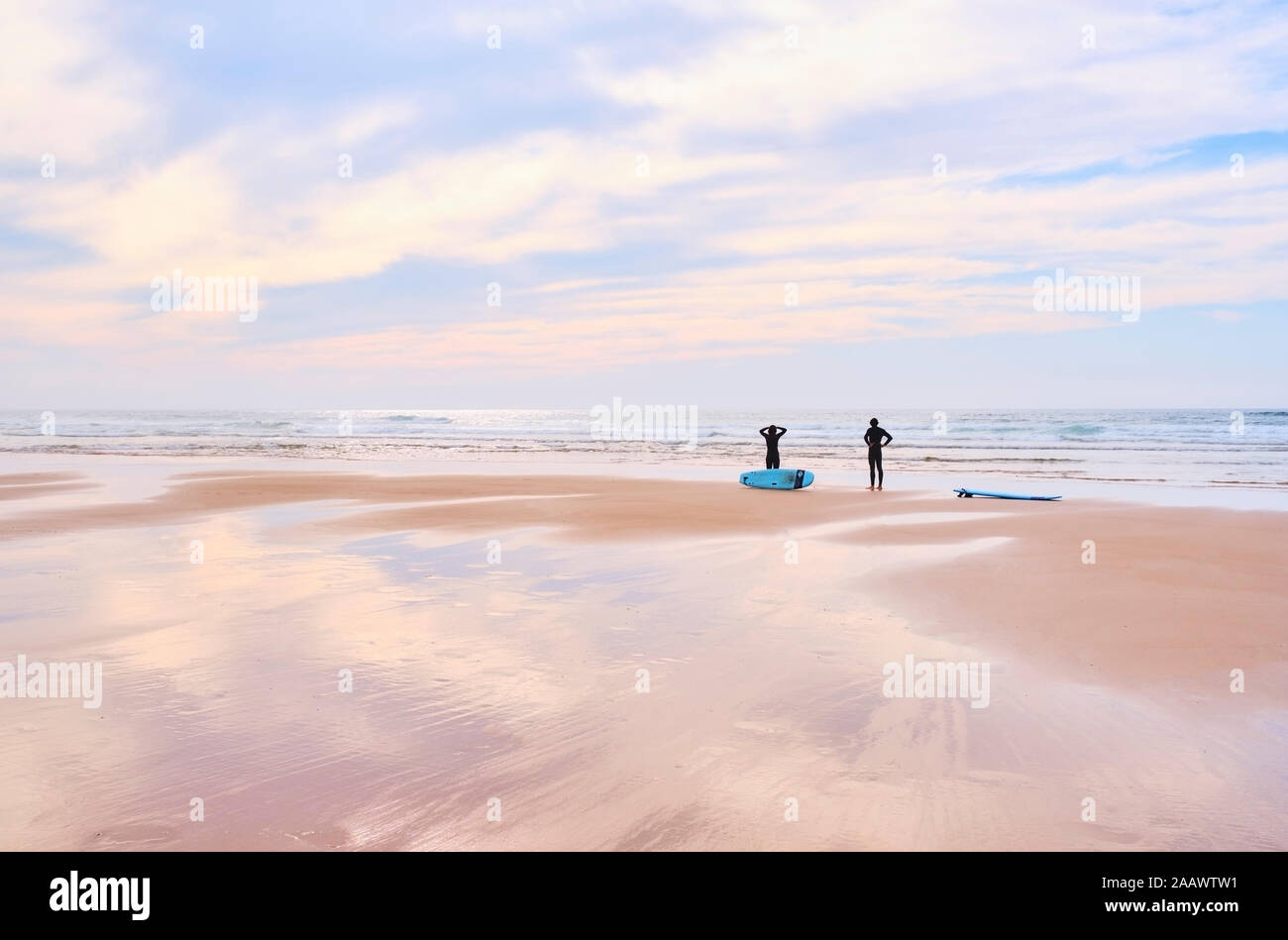 Portugal, Algarve, siluetas de dos surfistas en la playa de Cordoama permanente Foto de stock