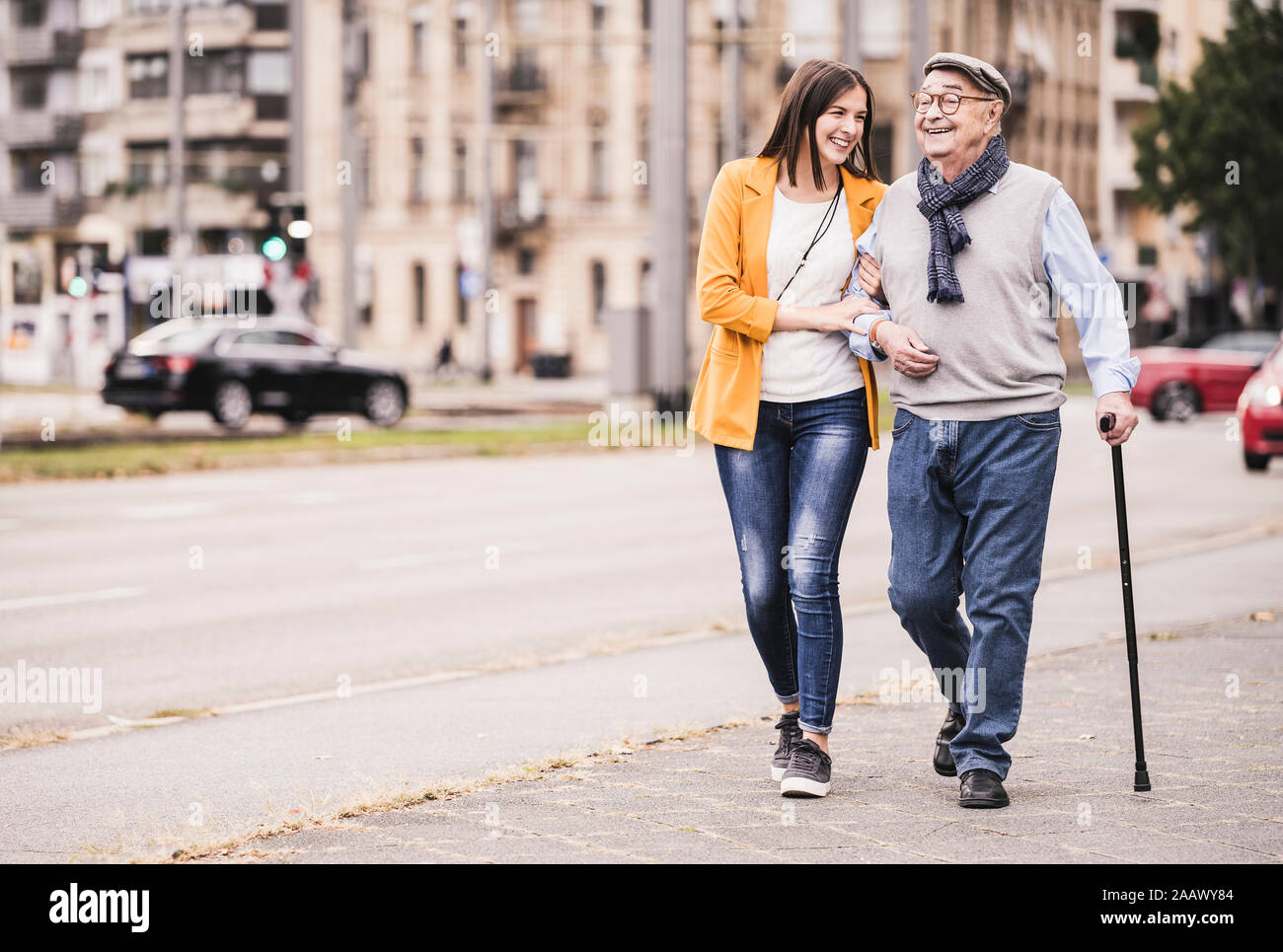 Nieta de adultos ayuda a su abuelo pasea con bastón Foto de stock