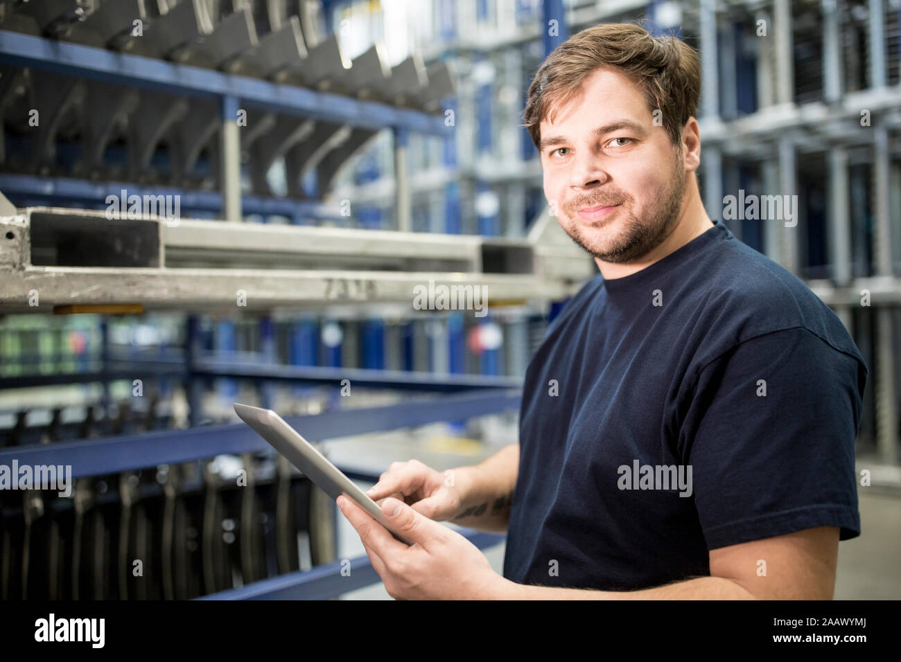 Retrato de seguro obrero con tableta en fábrica Foto de stock