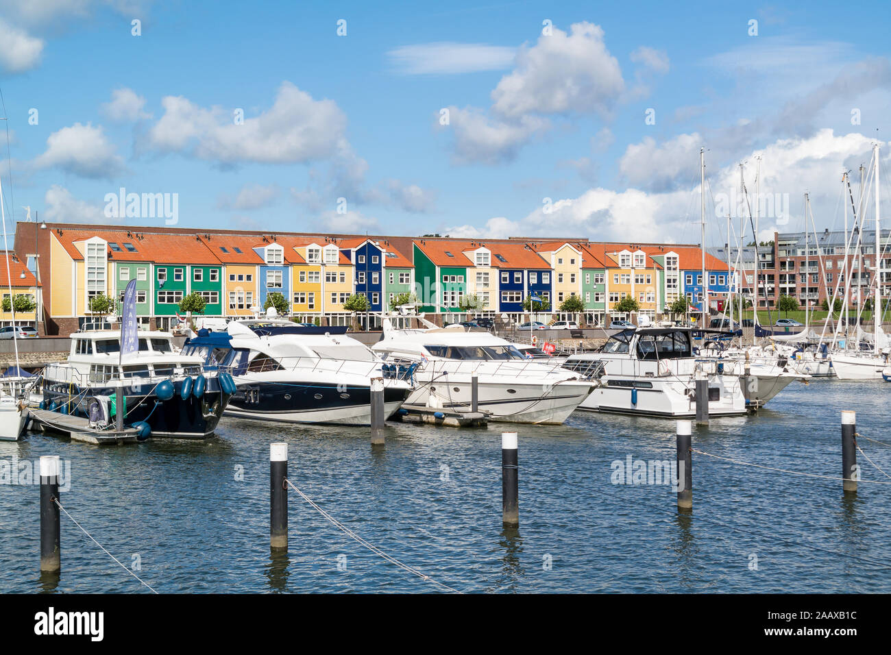 Coloridas fachadas de casas y yates a motor en marina Hellevoetsluis, Holanda Foto de stock