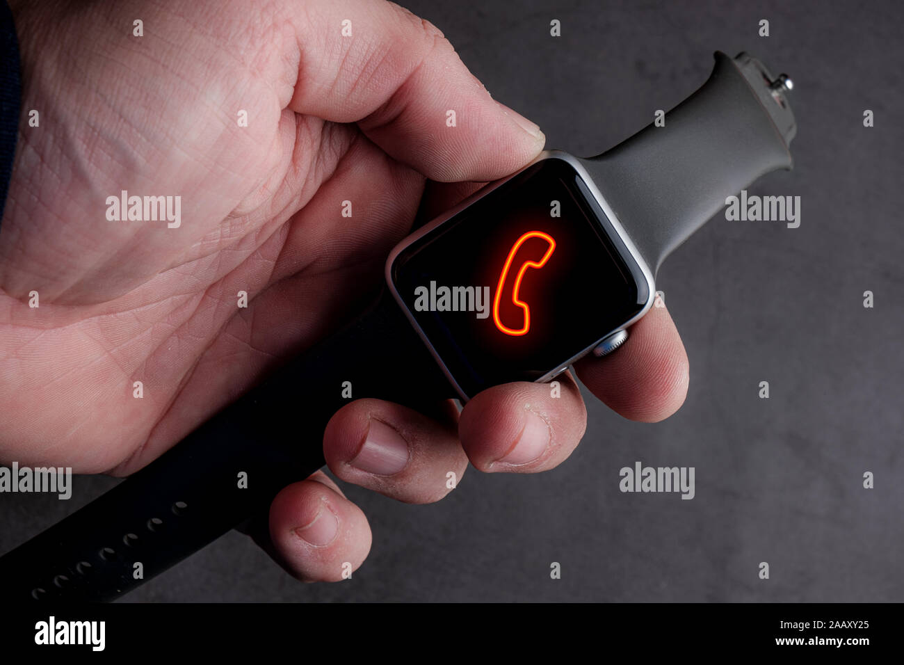 Hombre sujetando Smart Watch con la llamada el símbolo en la pantalla Foto de stock
