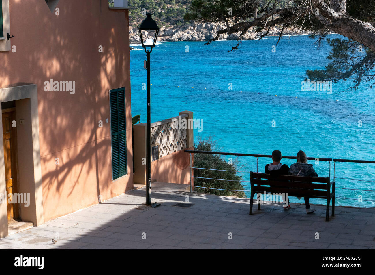 Dos personas en el asiento admirar vistas al mar Mallorca España Elm St Foto de stock