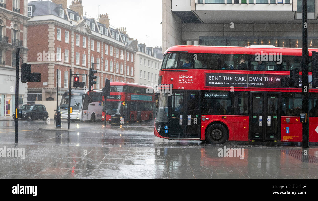 Red bus en lluvia Victoria Londres Inglaterra Foto de stock