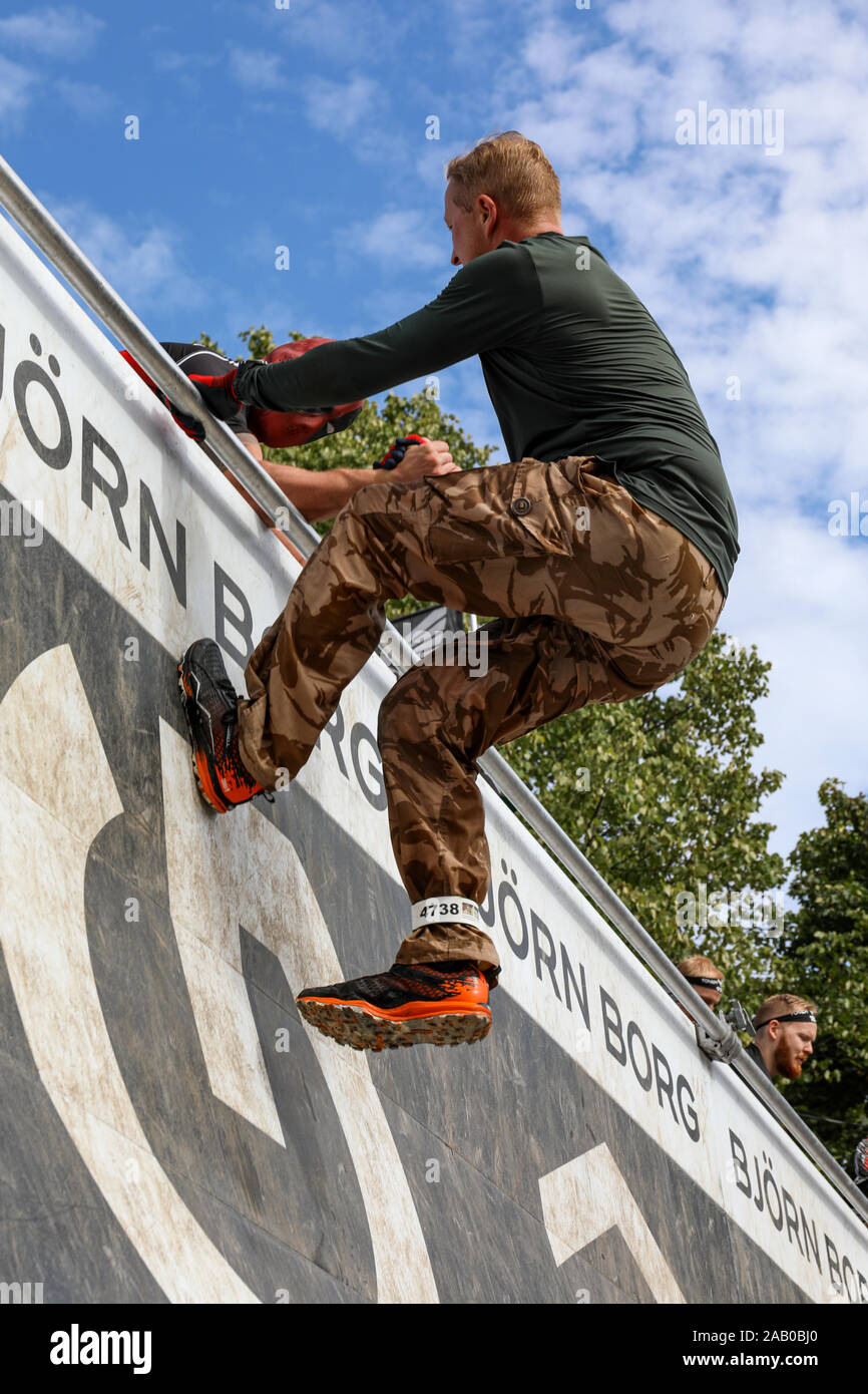 Viking dura carrera de obstáculos 2019 participante conquistar un obstáculo en Helsinki, Finlandia Foto de stock
