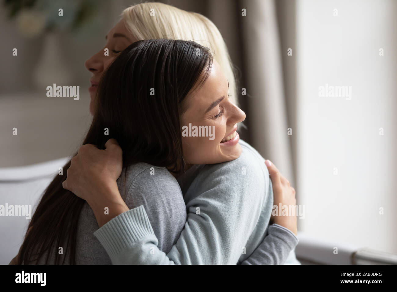 Cerrar imagen arriba crecido hija abrazarse madre anciana Foto de stock