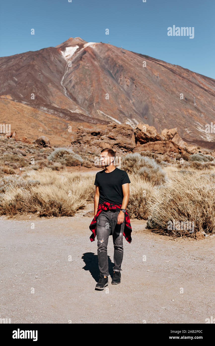 Elegante y moderno hombre sobre un fondo de montañas. Modelo de moda  masculina. Volcán Teide en Tenerife Fotografía de stock - Alamy