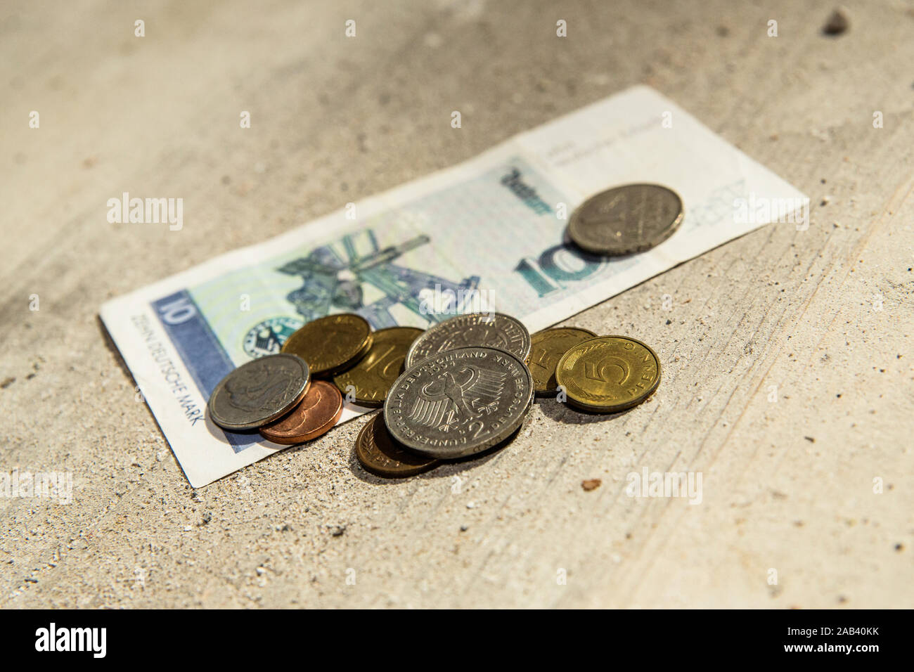 D-Mark Münzen und ein Geldschein liegen auf einem Fußboden |D-Mark monedas y un bill acostado sobre un piso| Foto de stock