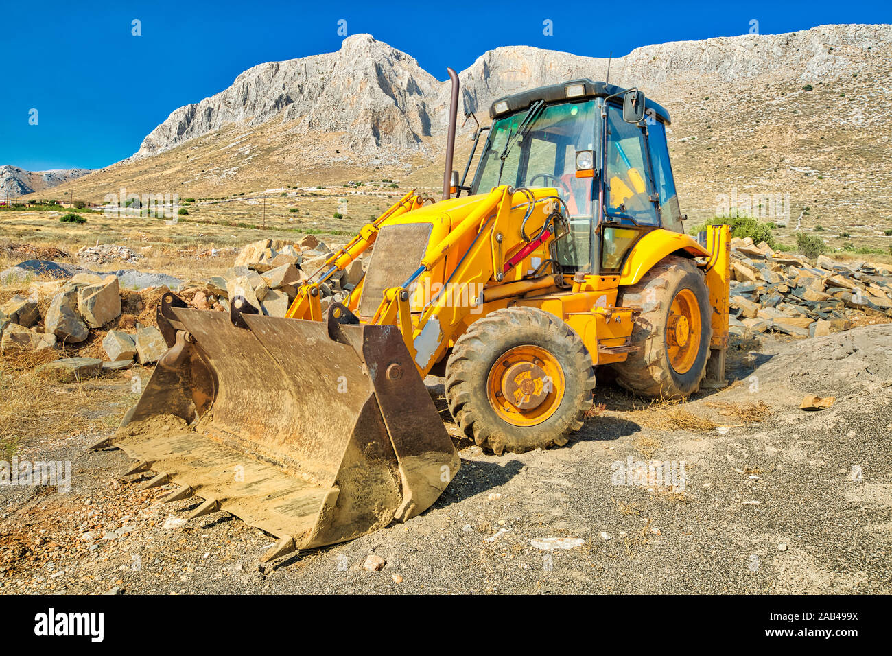 Vista lateral de la excavadora sobre ruedas para minas y pozos para la construcción en un sugerente sitio minero. Trabajo en progreso, máquina industrial. Foto de stock