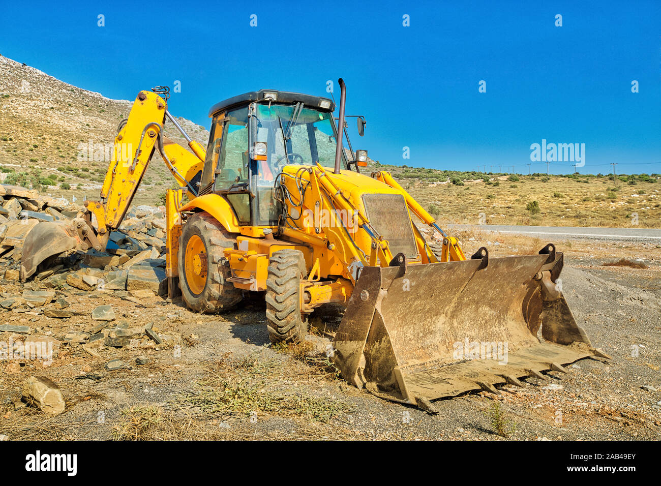 Vista lateral de la excavadora sobre ruedas para minas y pozos con brazos largos para la excavadora en el sitio minero. Trabajo en progreso, máquina industrial. Minería Foto de stock
