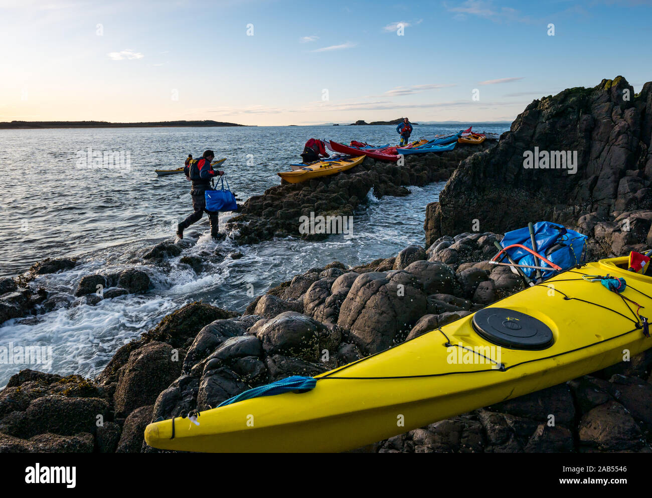 Kayak de Mar Club Lothian se preparan para abandonar de orilla rocosa con kayaks, Isla de cordero, Firth of Forth, Escocia, Reino Unido Foto de stock
