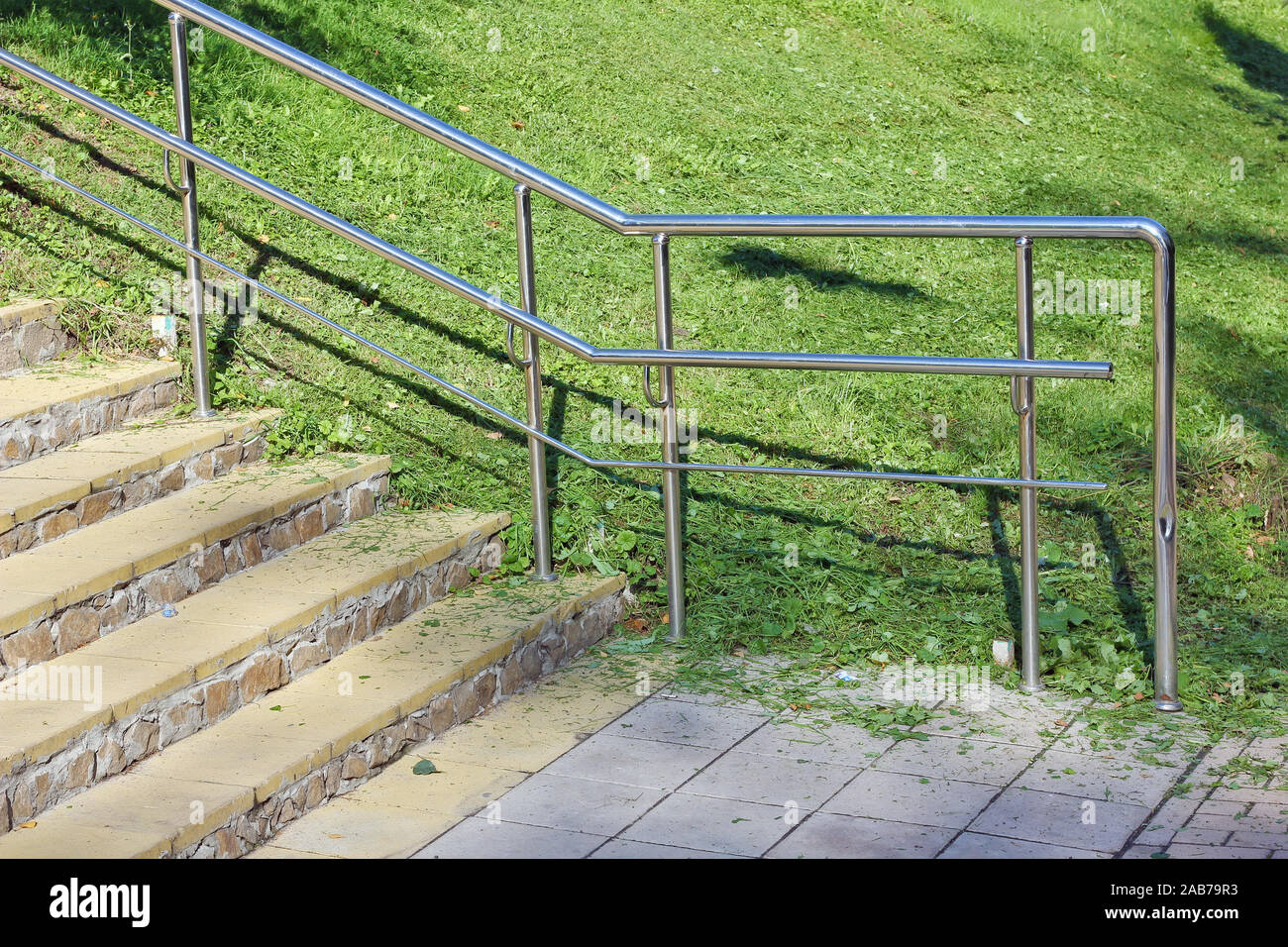 Escalera De Piedra Con Barandillas De Acero Inoxidable En El Parque.  Ascenso Por Una Pendiente Empinada A Lo Largo De Las Escaleras. Fotos,  retratos, imágenes y fotografía de archivo libres de derecho.