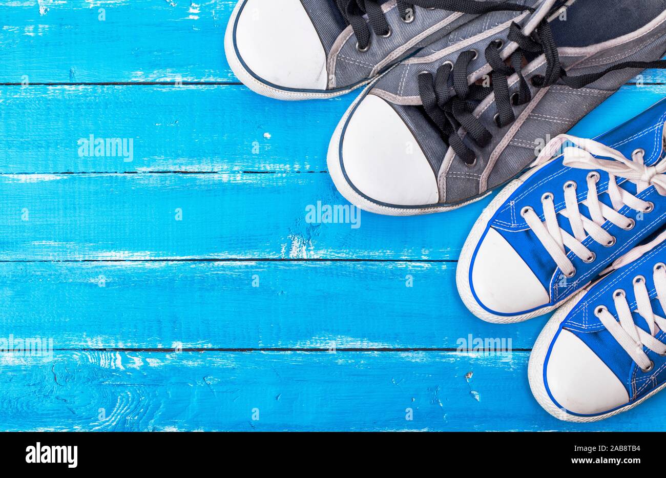 Dos pares de zapatillas azules textil sobre un fondo de madera, placas de  desgaste en el espacio vacío de la izquierda Fotografía de stock - Alamy