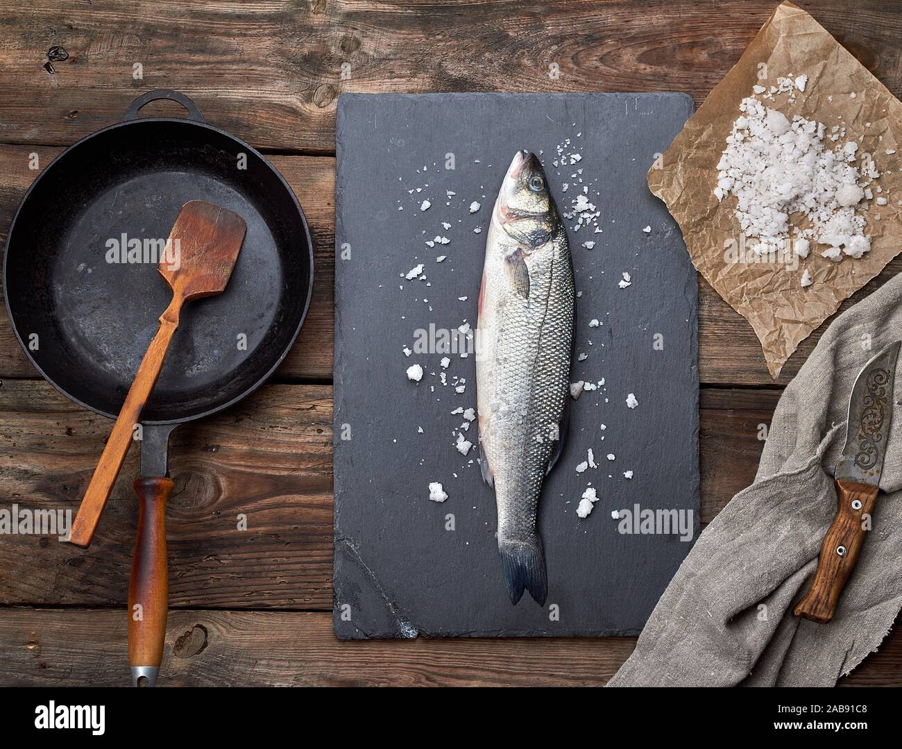 Lubina Fresco Pescado En Una Junta De Grafito Negro Junto A él Se Vacía Por Un Sartén Redondo Negro Sobre Una Mesa De Madera Vista Superior Fotografía De Stock Alamy<script async src=