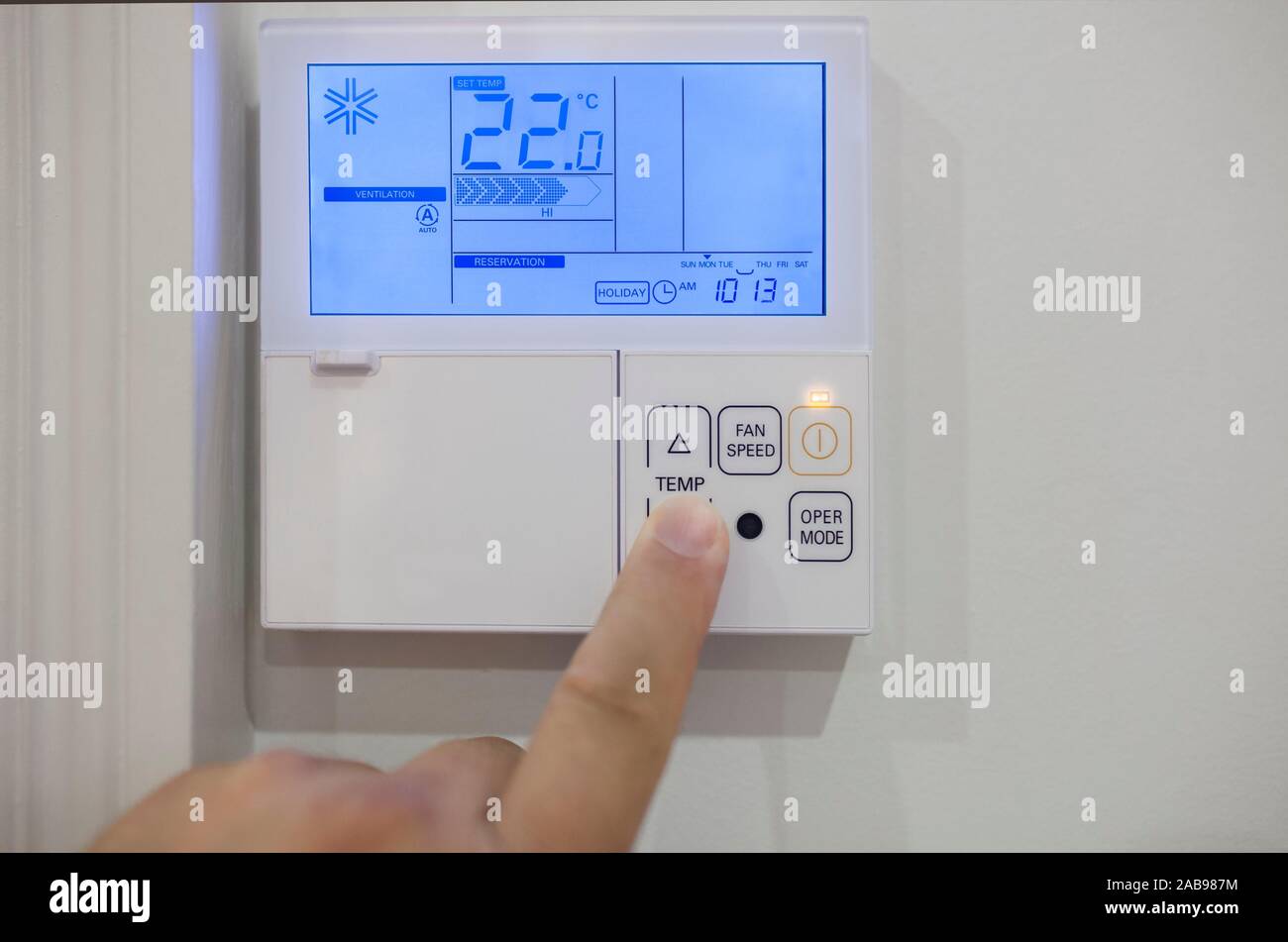 Ajuste de temperatura con control de dispositivos electrónicos en el hogar. Dedo presiona a 19 grados celsius. Foto de stock