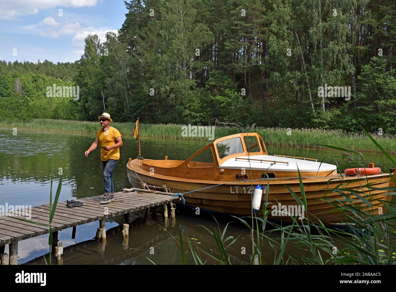Viaje en lancha de madera a lo largo de los lagos que rodean Paluse, Parque Nacional de Aukstaitija, Lituania, Europa. Foto de stock