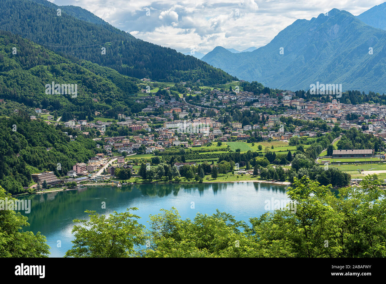 Vista aérea de la pequeña ciudad de Levico Terme con el Lake (Lago di Levico) y las montañas de los Alpes. Trentino Alto Adige, Italia, Europa Foto de stock