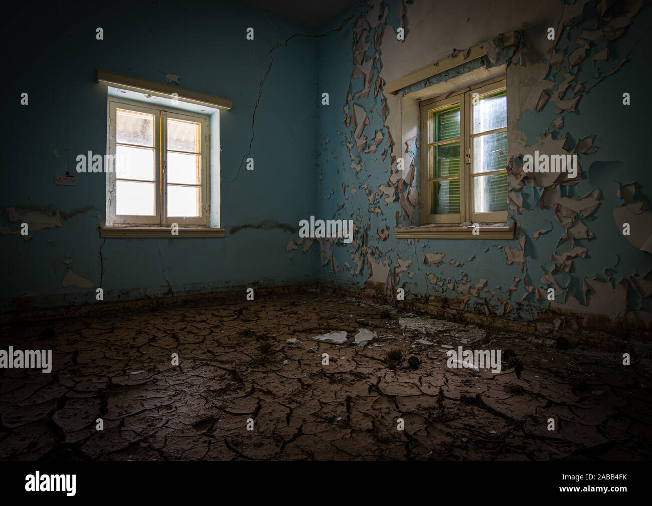 Interior de un sucio y demolido vacía abandonada con la ventana abierta y seca el barro agrietado Foto de stock