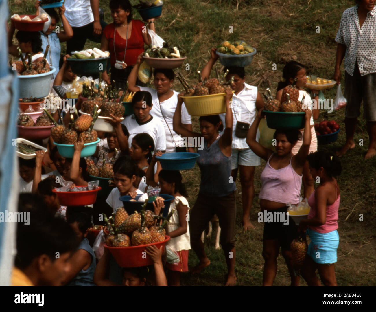 Cuando un barco atraca en un remoto, fluviales, comunidad Cocama indígena en la Amazonía peruana, los aldeanos se apresuran a vender comida a los pasajeros. Foto de stock