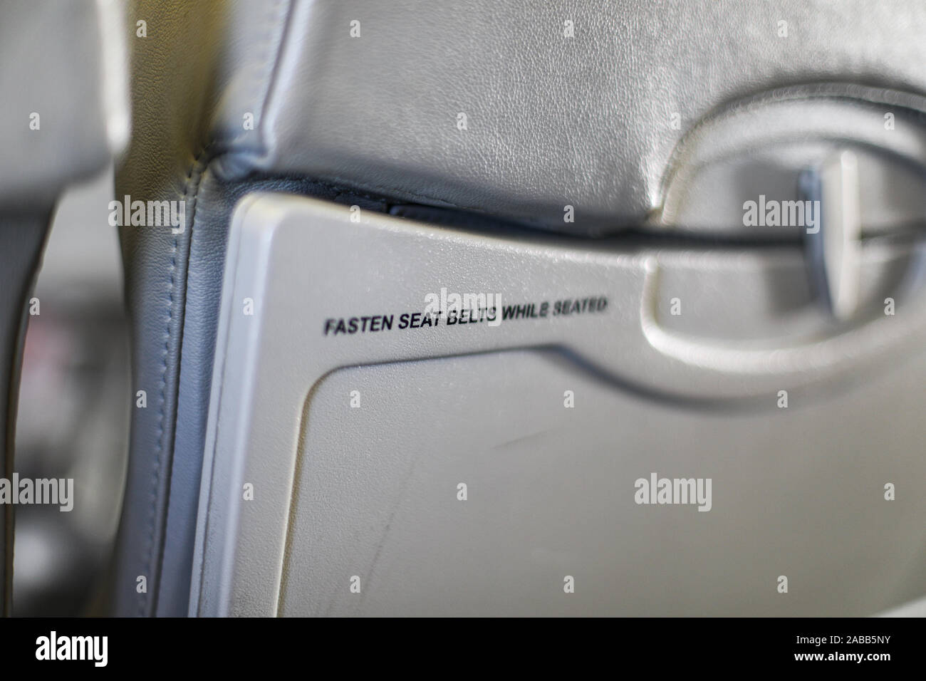 Abrocharse los cinturones de seguridad mientras se está sentado en el asiento del avión -texto BANDEJA. El enfoque selectivo. Copyspace. Copie el espacio. La industria de viajes. Foto de stock