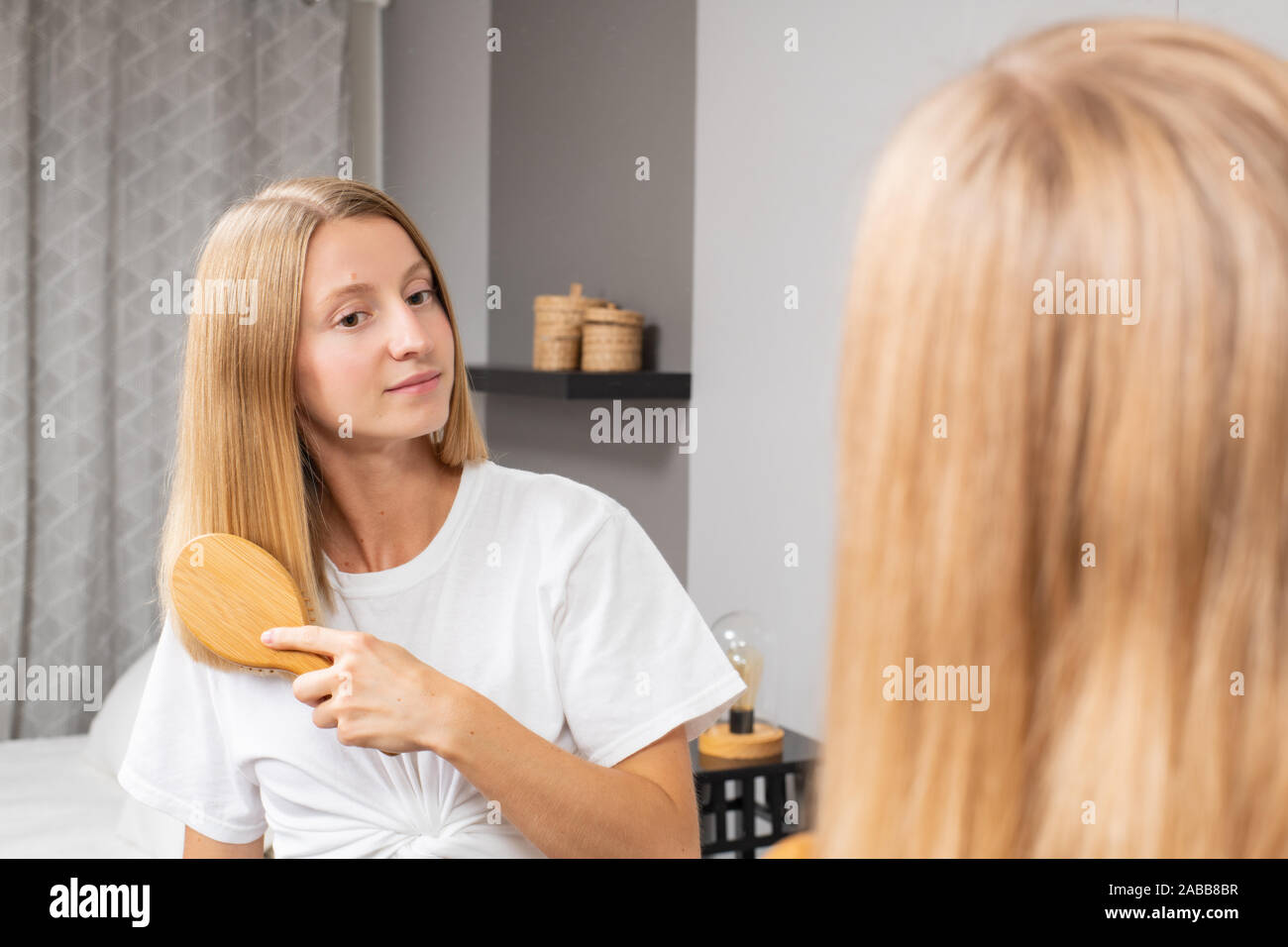 Hermosa Muchacha Peinando El Cabello Con Un Cepillo Mujer Rubia Peinarse El Pelo En Casa Mire En El Espejo Fotografia De Stock Alamy