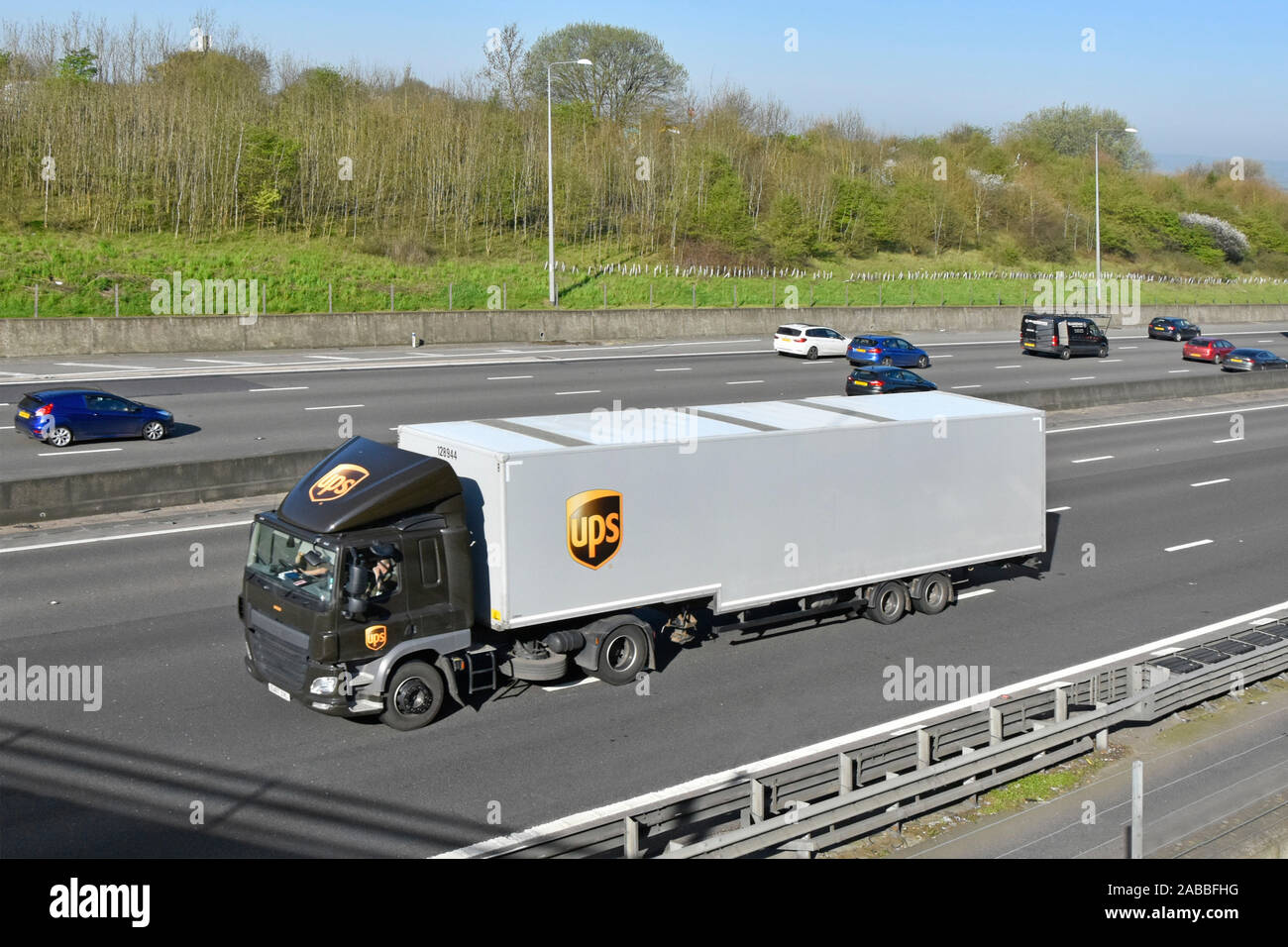 Logística de la cadena de suministro transporte de envíos de UPS United Parcel Service, el logotipo de marca de camión pesado camión articulado y lateral autopista trailer English UK Foto de stock