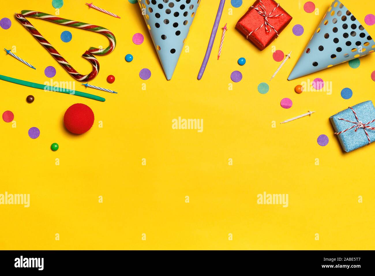Cumpleaños de fondo amarillo con parte caps presenta confeti dulces. Copie el espacio. Foto de stock