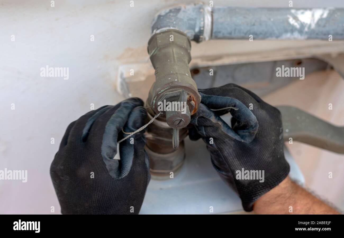 Quita el trabajador juntas a la conexión entre el tubo y el contador de gas. Enfoque selectivo Foto de stock