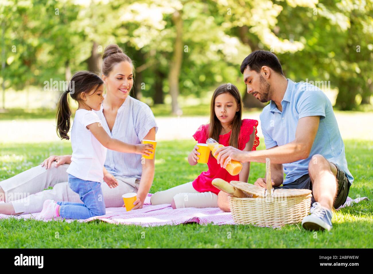 Familia de beber jugo de picnic al parque de verano Fotografía de stock -  Alamy