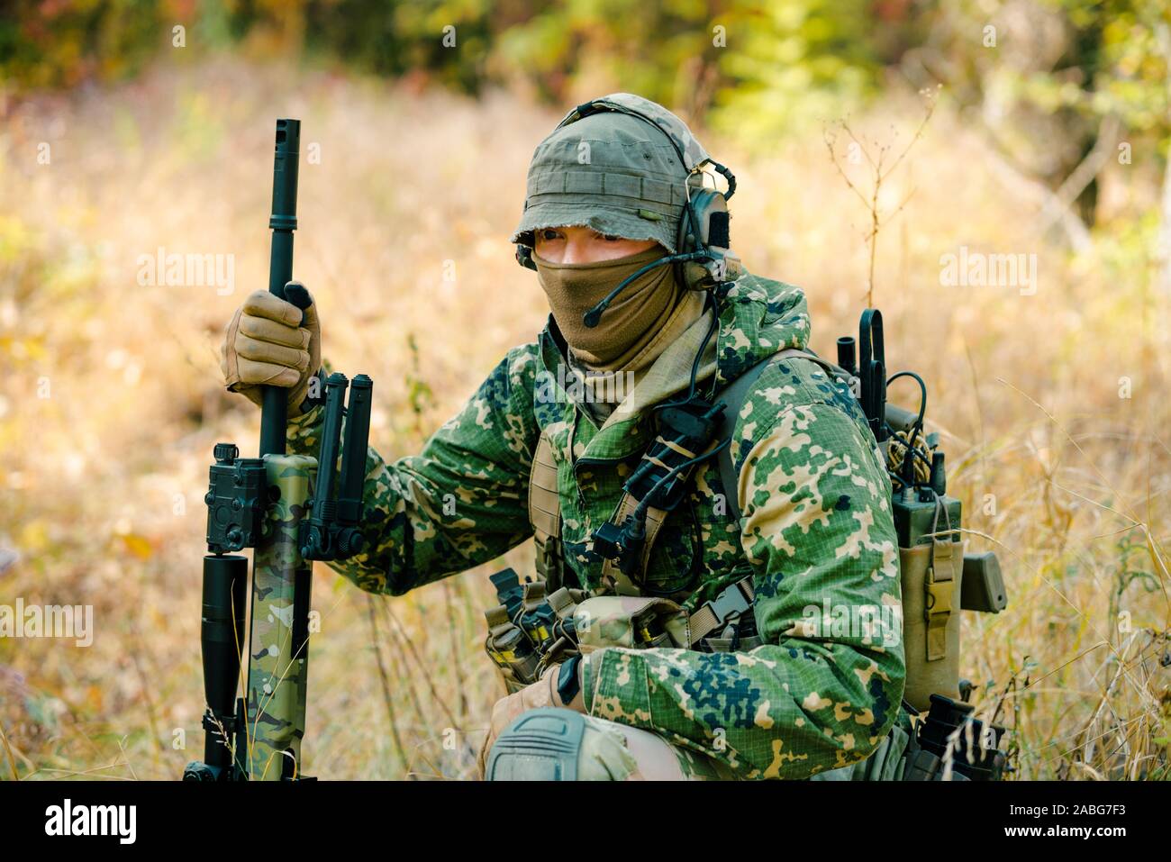 Airsoft hombre uniformado mantenga un rifle de francotirador en