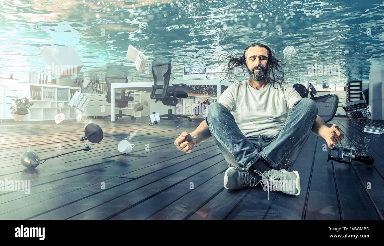 Hombre sentado bajo el agua que relaja en una posición de yoga. Oficina totalmente inundada. Concepto de problemas y calma. Foto de stock